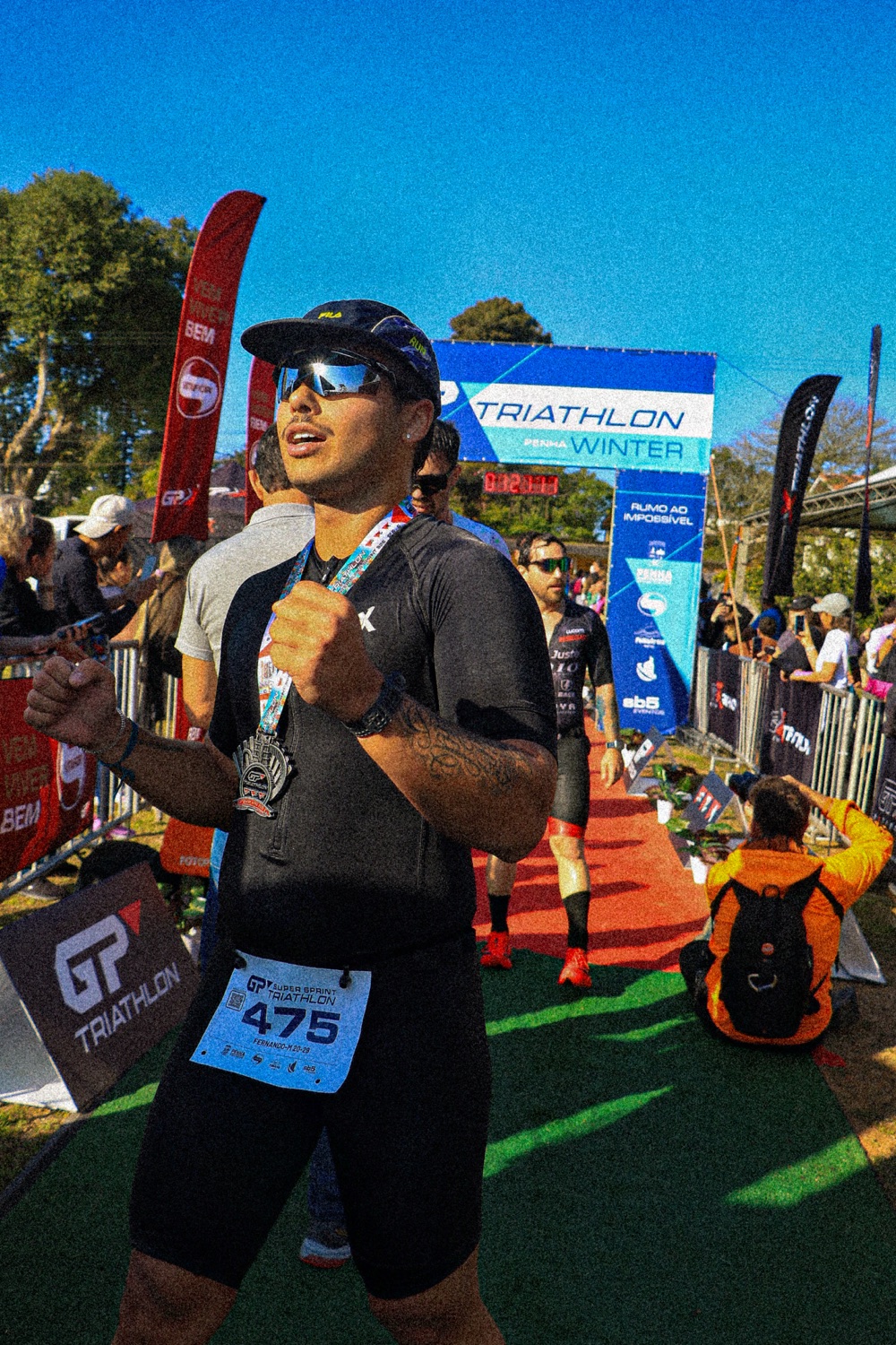 Coach Fernando at a triathlon finish line, medal around the neck